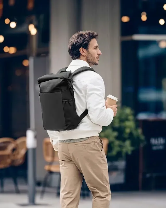 Roll-top backpack carried down a city street