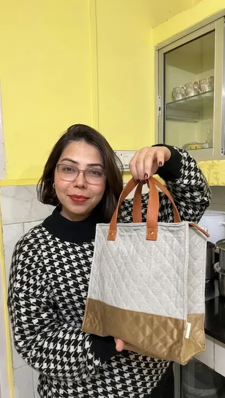 Two-tone quilted tote held with tan leather handles